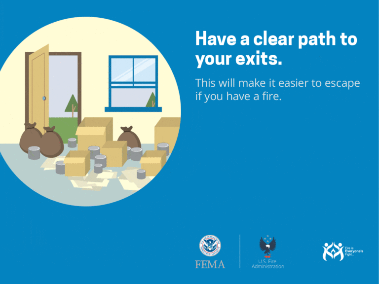 Illustration of a room filled with boxes and bags blocking a door and window. Text reads: "Have a clear path to your exits. This will make it easier to escape if you have a fire." Logos of FEMA, U.S. Fire Administration, and "Fire is Everyone’s Fight" are shown.