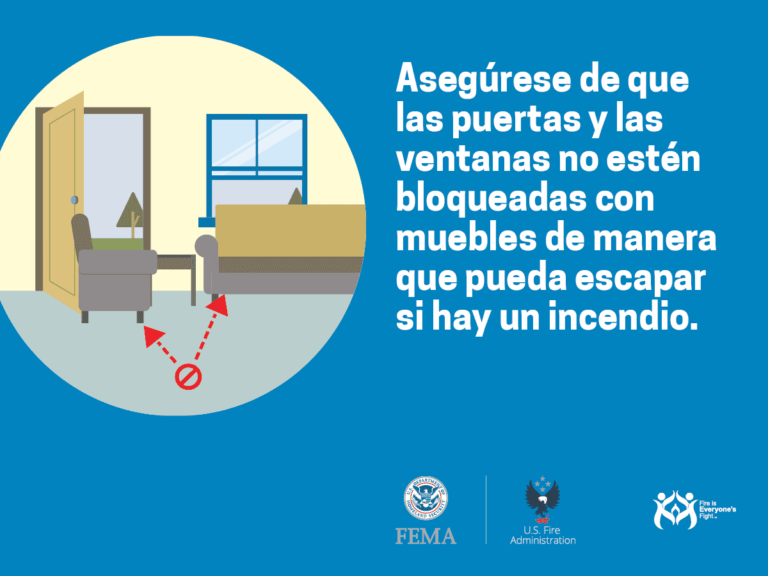 Illustration of a room with an armchair blocking a door and window, indicated by arrows and a prohibition symbol. Spanish text advises keeping doors and windows unblocked in case of fire. Features FEMA and U.S. Fire Administration logos.